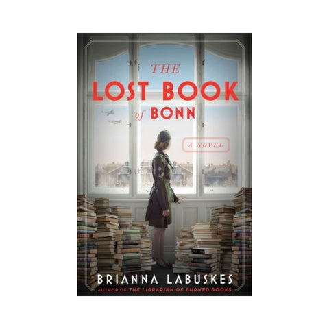 Book cover of 'The Lost Book of Bonn' by Brianna Labuskes with a woman standing in front of a window.
